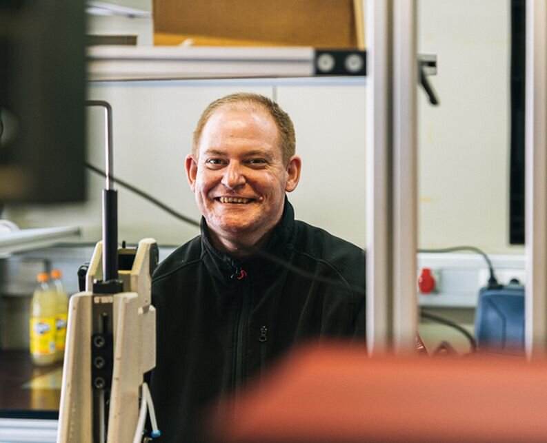 Ein freundlicher Mann in einer Werkstatt.